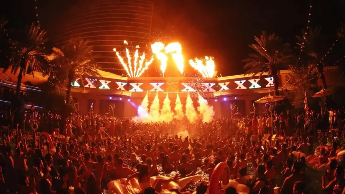 XS Nightclub venue video thumbnail with illuminated pool deck, cabanas, and late-night club lighting.